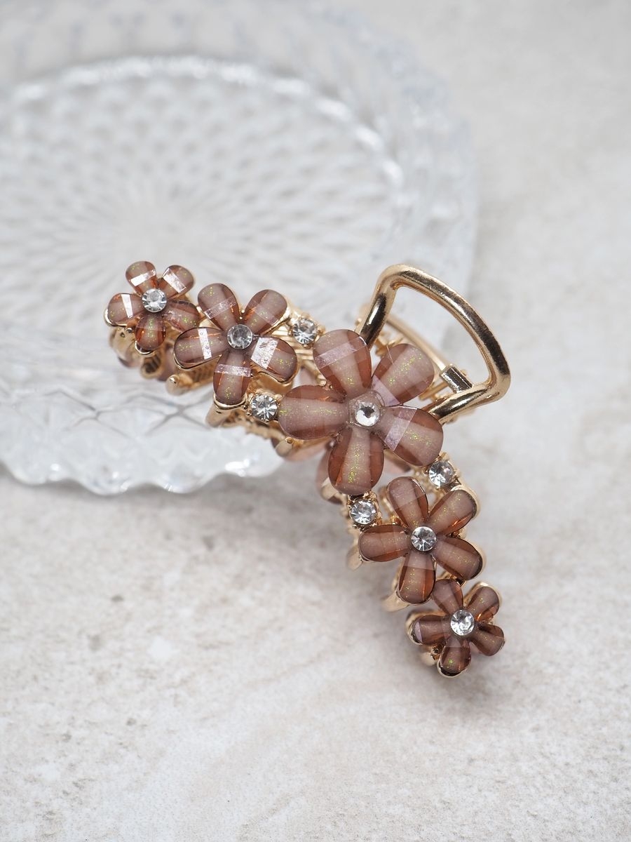 Hårklyper med blomster, glitter og blanke glasstener. Sitter supergodt i håret. 
Klypen har gulldetaljer.

Lengde 7cm, høyde 3cm, medium stor klype