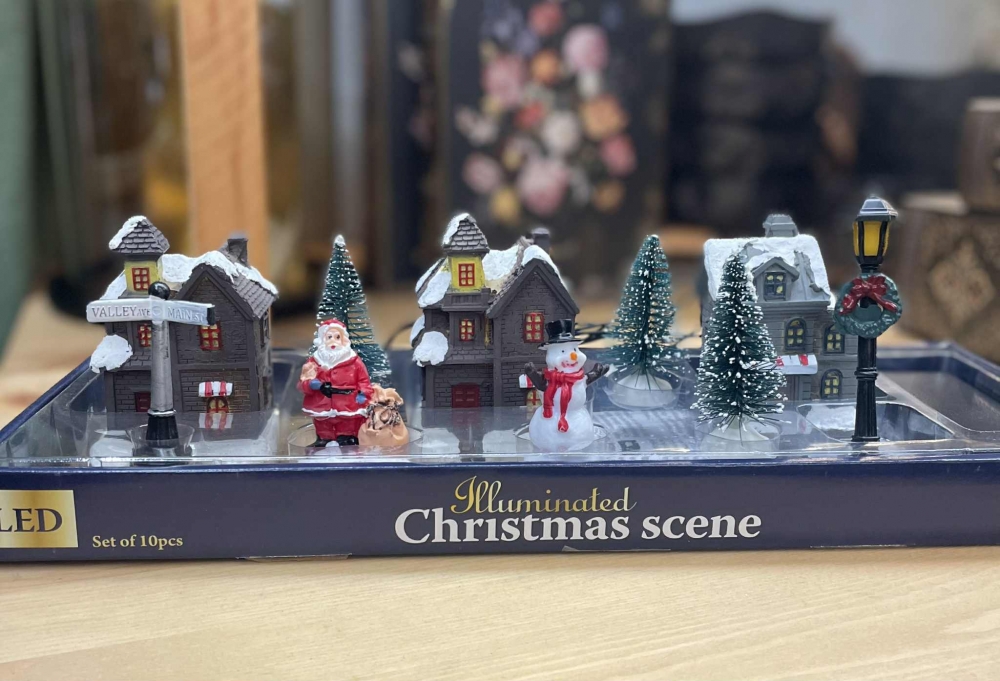 Koselig juleby med små bygninger og figurer. Led lys, 2 AA batterier.