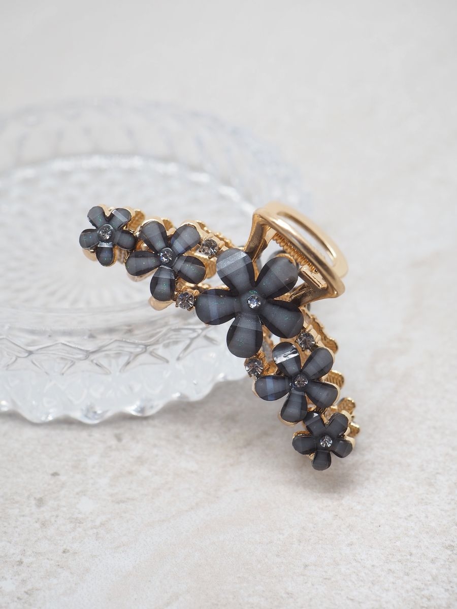 Hårklyper med blomster, glitter og blanke glasstener. Sitter supergodt i håret. 
Klypen har gulldetaljer.

Lengde 7cm, høyde 3cm, medium stor klype