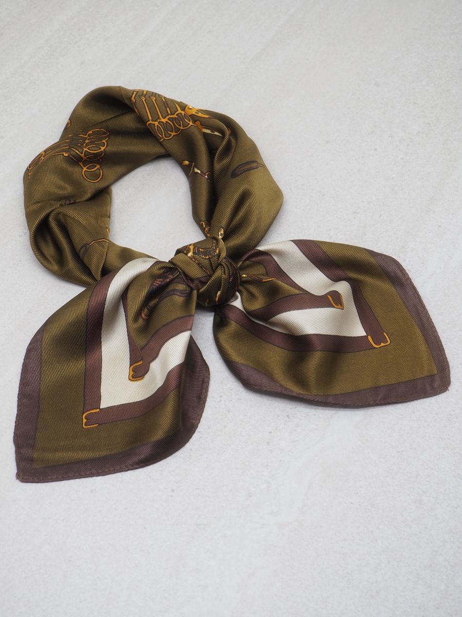 Dette satengskjerfet kombinerer olivengrønn og brun i et klassisk hestemotiv, og gir antrekket et elegant og lekent preg. Skjerfet er laget i 100% polyester med glansfull, myk overflate som føles behagelig mot huden.