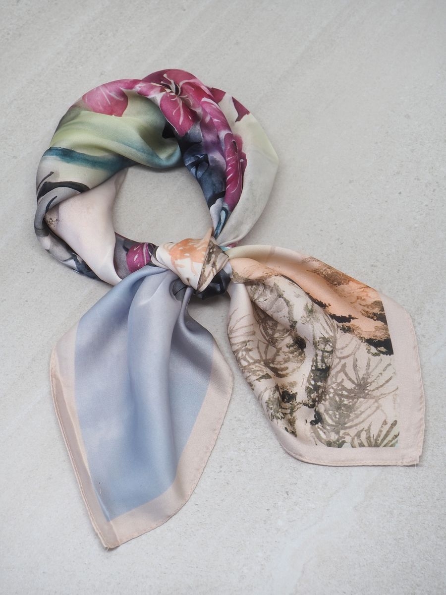 Lekkert satengskjerf i en nydelig kombinasjon av beige og lilla. Skjerfet er laget i glatt polyester med en myk og skinnende satengfinish, som gir et sofistikert uttrykk.