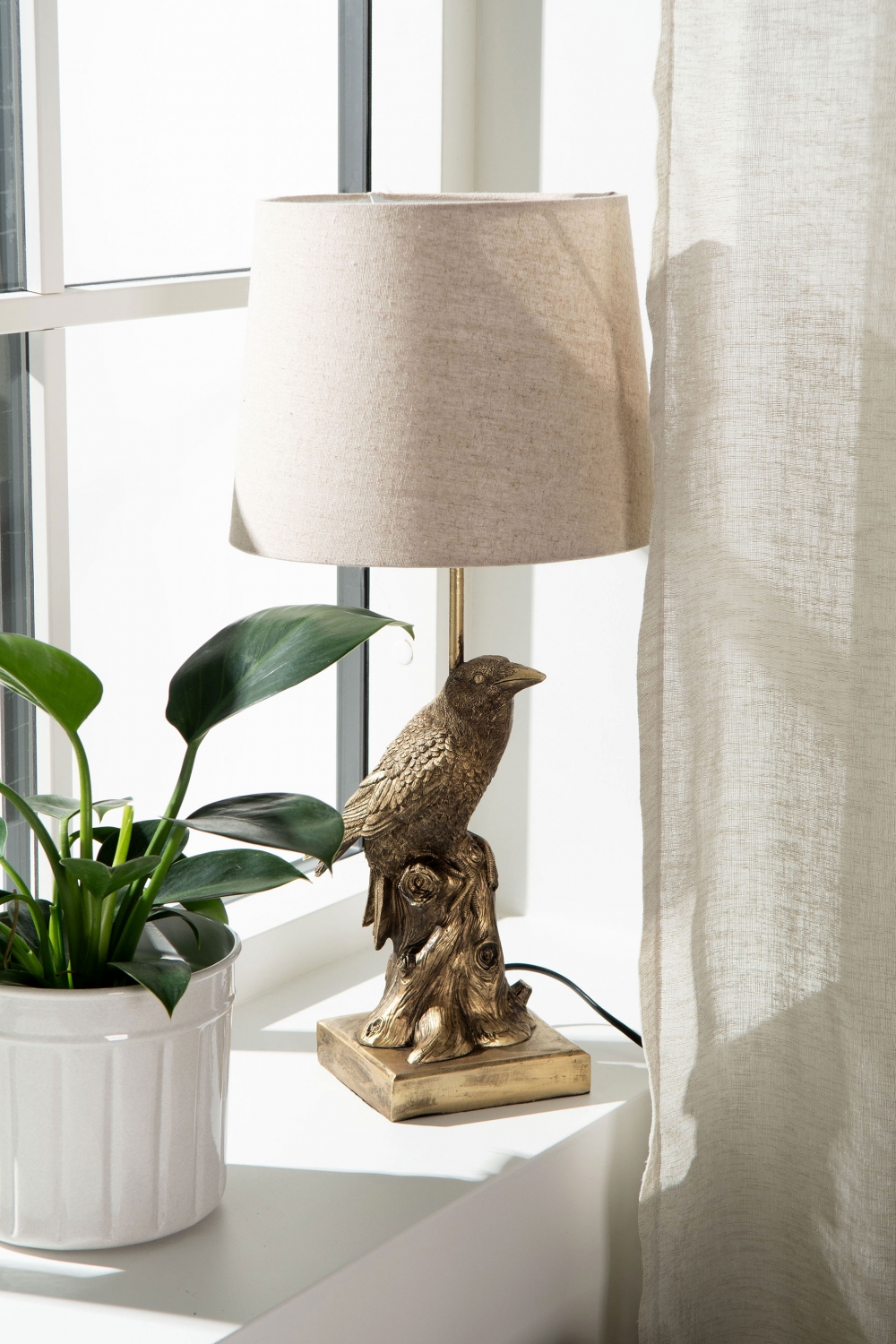 Dekorativ lampefot med en kråke som sitter på et tre. 14 x 13 x 41 cm. Passer fint med lampeskjermen lin natur.