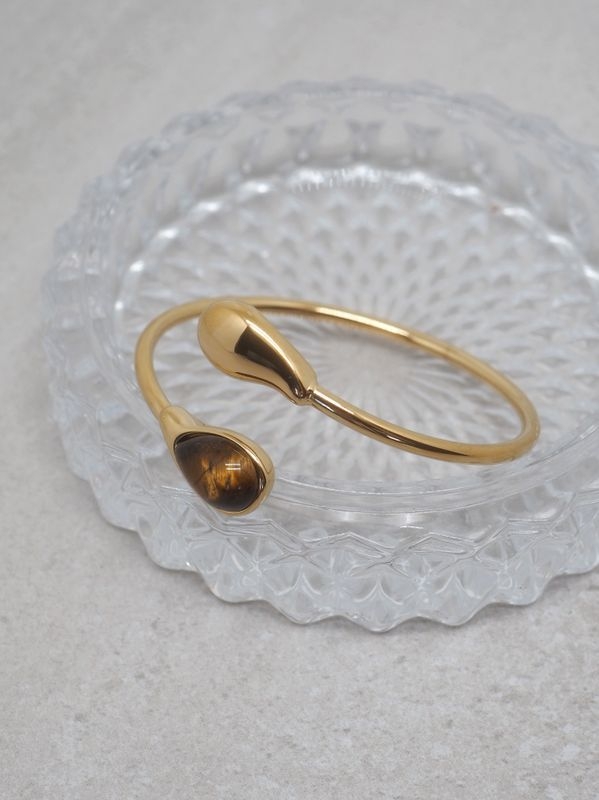En classy og kul armring som er høstens store trend. Armringen er laget i stål med en vakker brun stein, og siden den er i stål holder fargen seg fin over tid – uten avskalling eller falming.