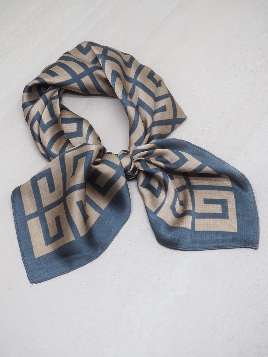 Et elegant skjerf i sateng med klassiske farger blå og brun – tidløst, allsidig og lett å style. Skjerfet er laget av 100% polyester, som gir en glatt, myk overflate med lett glans og behagelig følelse mot huden.