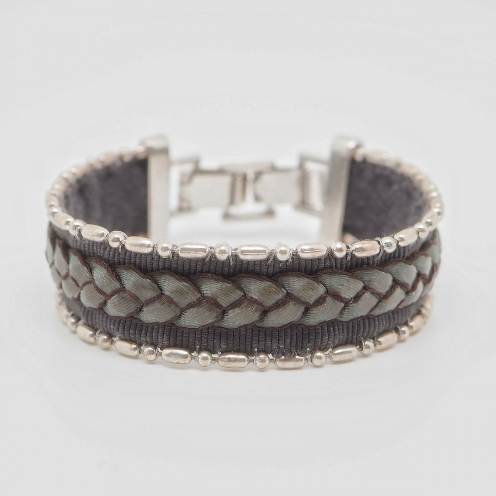 Bomull armbånd som er dekorert med skinnflette og sølvperler.

Nikkelfritt.