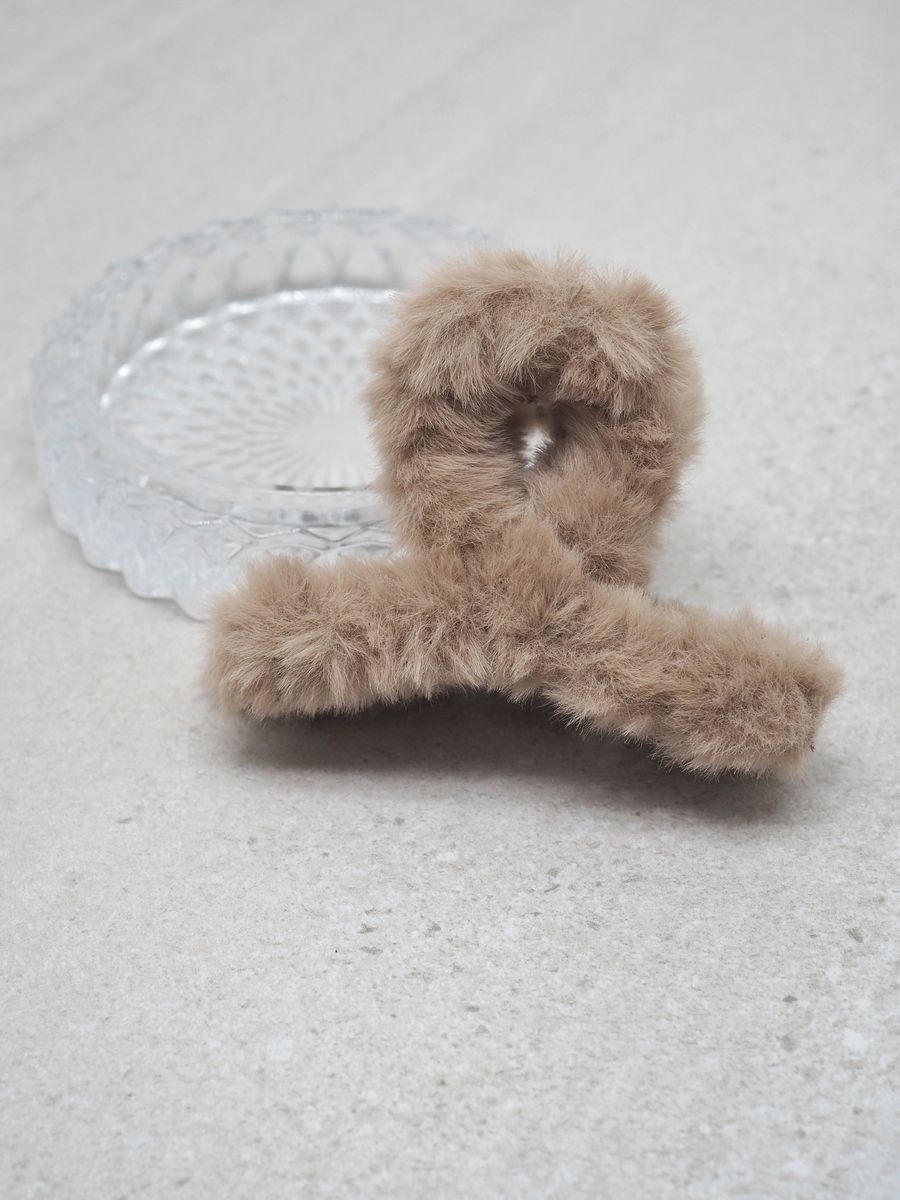 Denne store hårklypen med fuskepels i beige kombinerer komfort og stil på en elegant måte.
Den sitter godt i håret og gir frisyren et mykt, luksuriøst uttrykk – perfekt både til hverdags og fest.