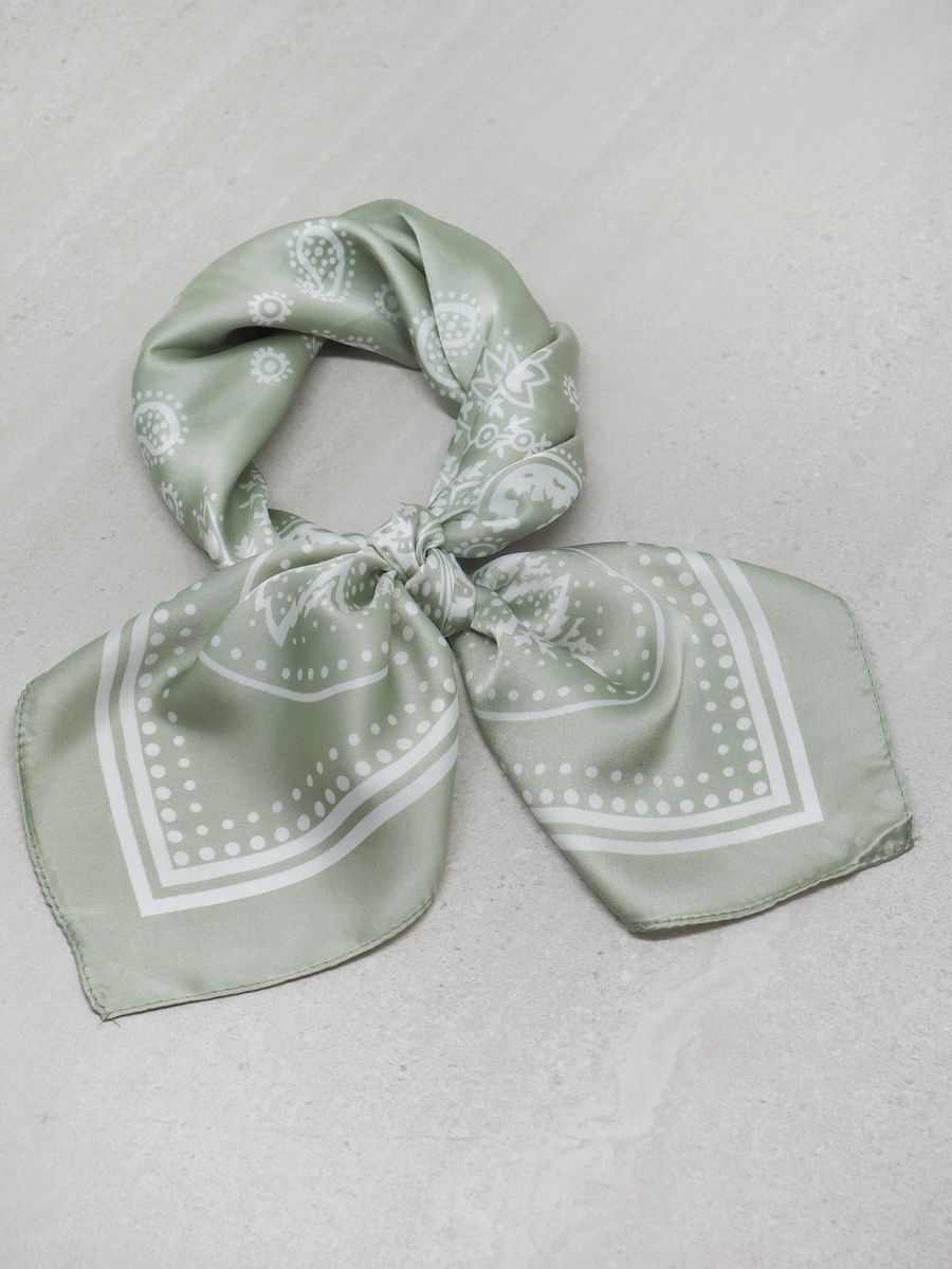 Dette klassiske satengskjerfet i lysegrønn og off-white er et tidløst tilbehør som løfter ethvert antrekk. De rolige og elegante fargene gjør skjerfet enkelt å kombinere med både lyse og mørke plagg, og det passer like godt til hverdagsbruk som til fest.