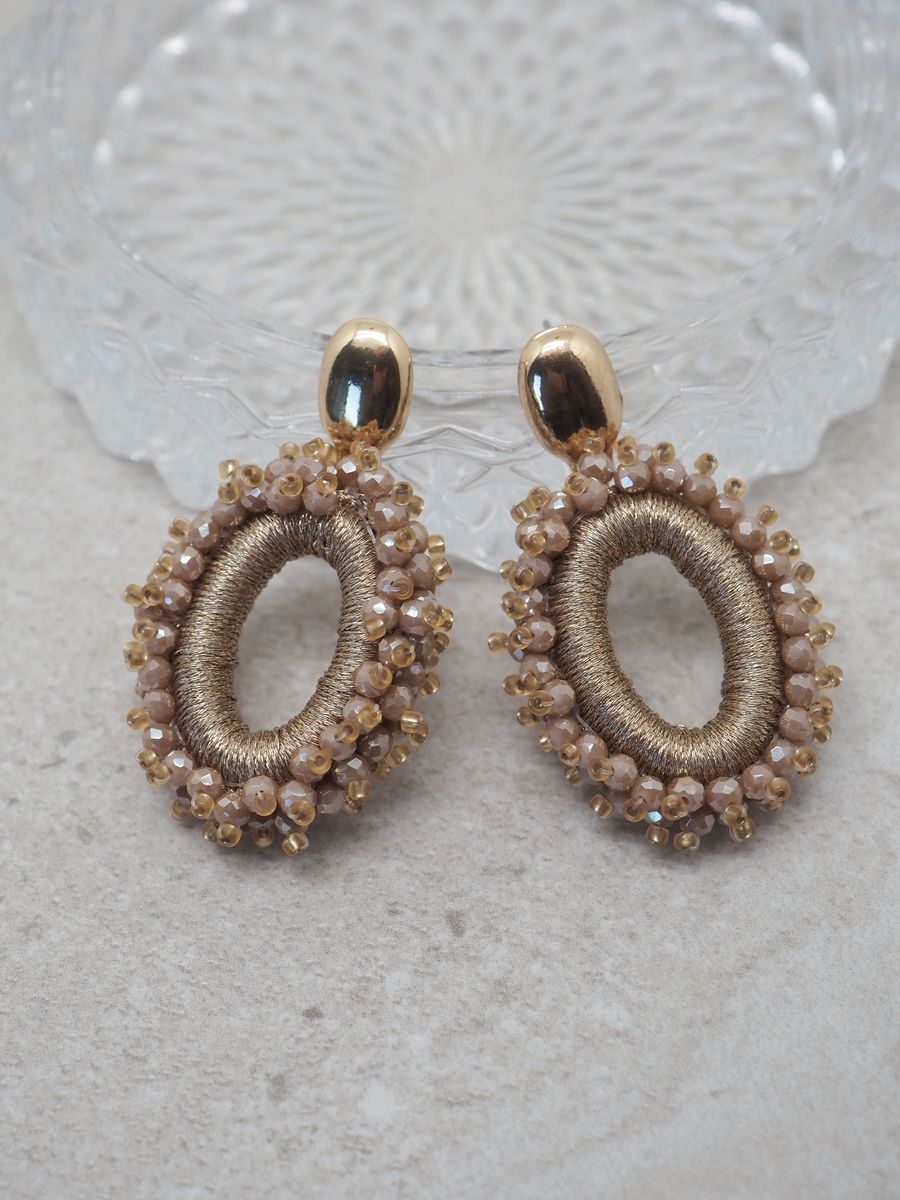 Glitre på festen med disse elegante øredobbene med champagnefargede glasssteiner. Med en lengde på ca 5,5 cm gir de et sofistikert og iøynefallende uttrykk, samtidig som de er lette og behagelige å ha på gjennom hele kvelden.