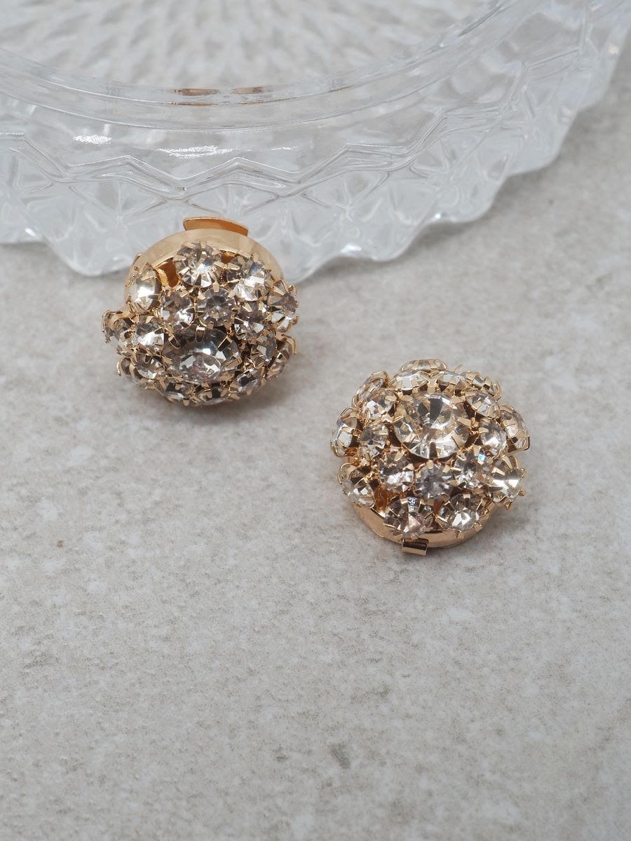 Gi antrekket et elegant løft med denne nydelige knappepynten formet som en blomst i gullfarge, pyntet med glitrende glassteiner. Perfekt for å skjule knapper på skjorter eller gensere – samtidig som den tilfører et delikat og luksuriøst uttrykk.