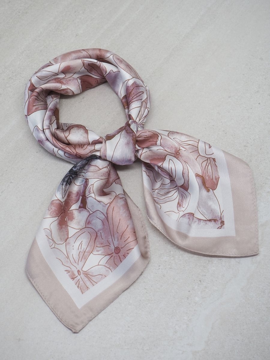 Dette stilfulle satengskjerfet kombinerer varme toner i beige og brunkorall som gir et mykt og sofistikert uttrykk. Skjerfet er laget av glatt polyester med satengfinish som gir en lekker glans og behagelig følelse.